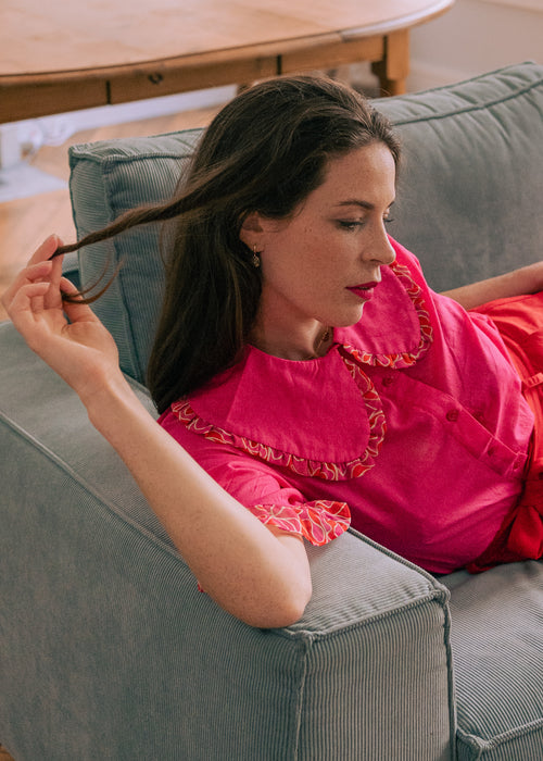 Une femme porte une chemise rose fuschia avec un maxi col claudine à fronces de la marque Magic Pill Paris