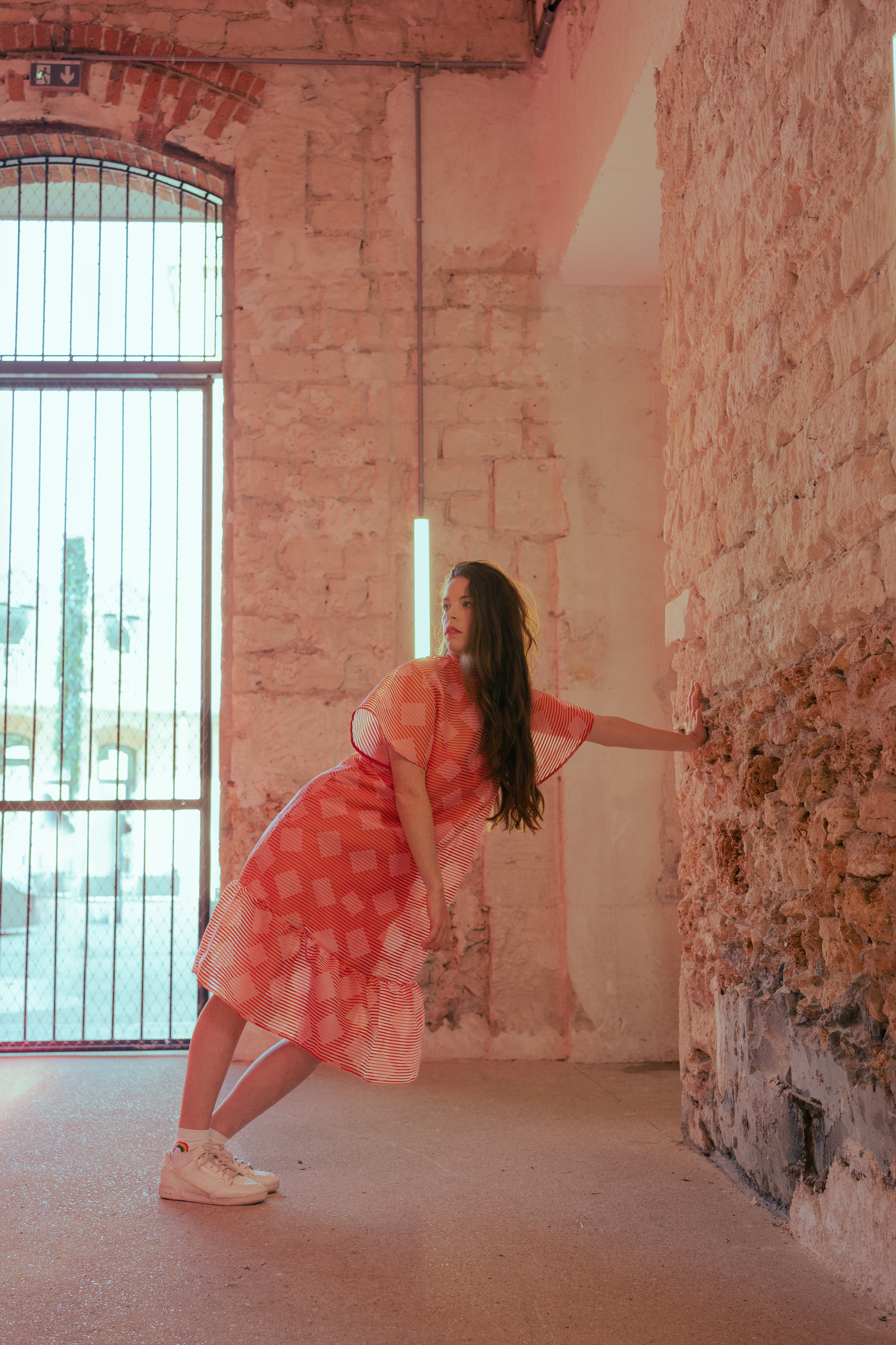 Photo du shooting de la marque de mode Made in France Magic Pill : une robe rouge et rose, élégante, mi-longue à motifs géométriques.